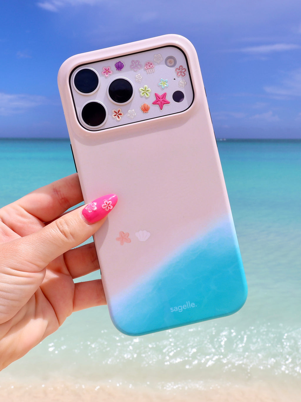 Sagelle beachin iPhone case with beach shoreline design held in front of a caribbean beach